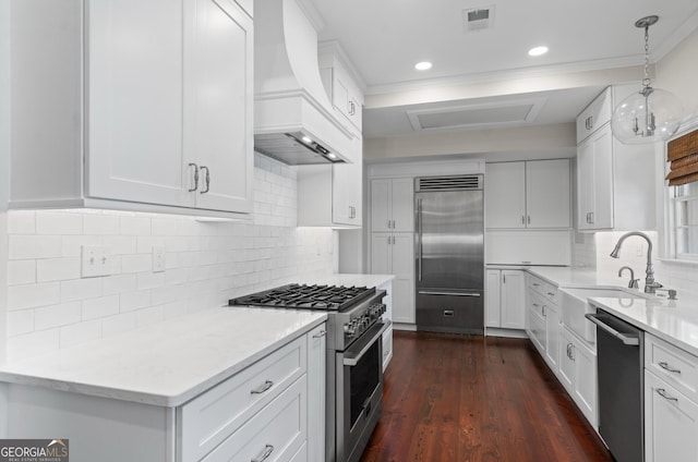 204 E Liberty St, Savannah, GA 31401 - kitchen with premium appliances, custom exhaust hood, a sink, white cabinets, and ornamental molding