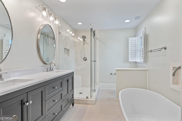 bathroom with a stall shower, tile patterned flooring, a sink, and visible vents