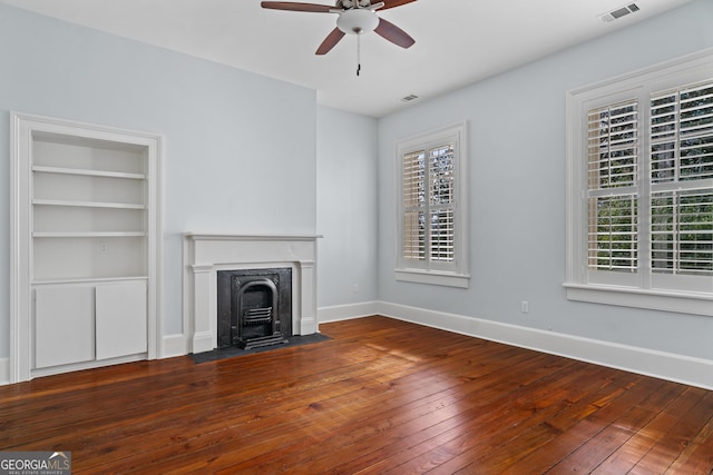 unfurnished living room with a ceiling fan, wood-type flooring, visible vents, and plenty of natural light