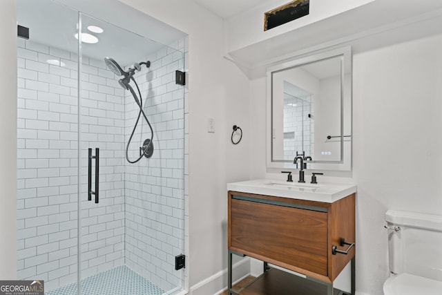 full bath with a stall shower, baseboards, vanity, and toilet