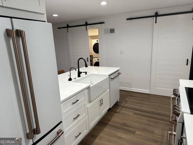 204 E Liberty St, Savannah, GA 31401 - kitchen with a barn door, white appliances, stacked washer / dryer, crown molding, and recessed lighting