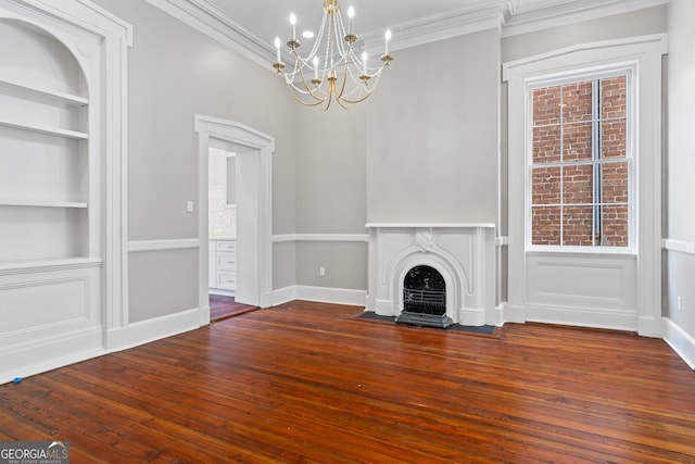 unfurnished living room featuring ornamental molding, a fireplace with flush hearth, hardwood / wood-style floors, and built in features