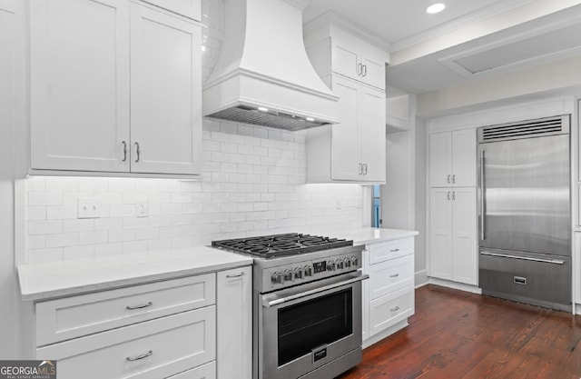 204 E Liberty St, Savannah, GA 31401 - kitchen featuring high end appliances, premium range hood, white cabinetry, dark wood-style flooring, and recessed lighting