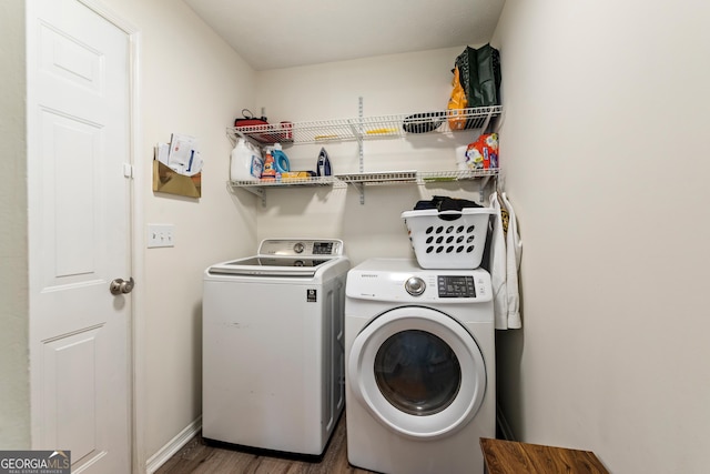 laundry area with laundry area, separate washer and dryer, wood finished floors, and baseboards