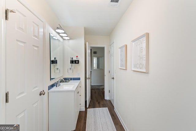 interior space featuring dark wood-style floors, a sink, visible vents, and baseboards