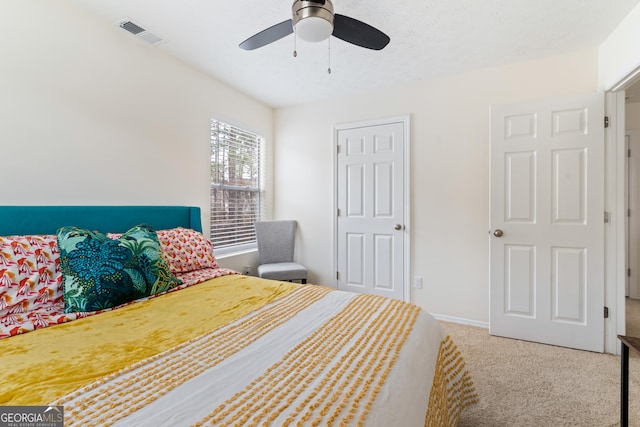 carpeted bedroom with ceiling fan, visible vents, and baseboards