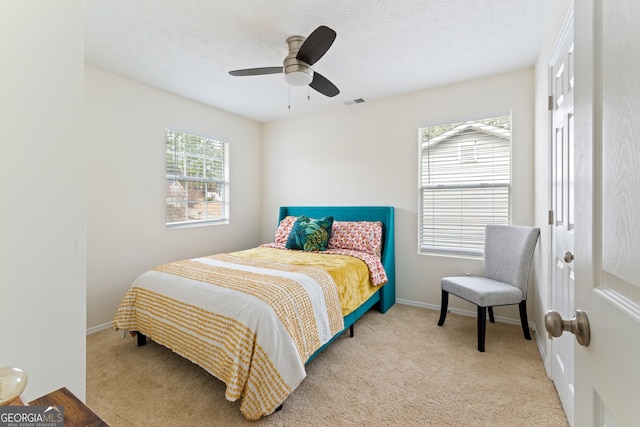 bedroom with ceiling fan, a textured ceiling, carpet, and baseboards