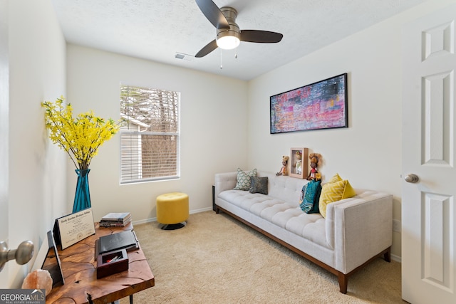 carpeted living room featuring visible vents, ceiling fan, a textured ceiling, and baseboards