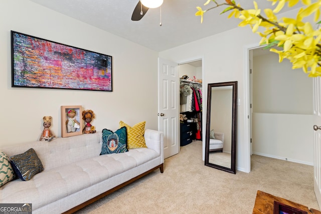 living area with ceiling fan, baseboards, and light colored carpet