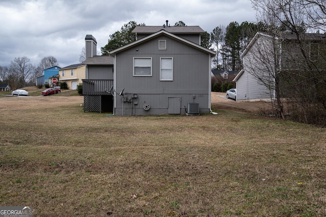 rear view of property with a yard and cooling unit