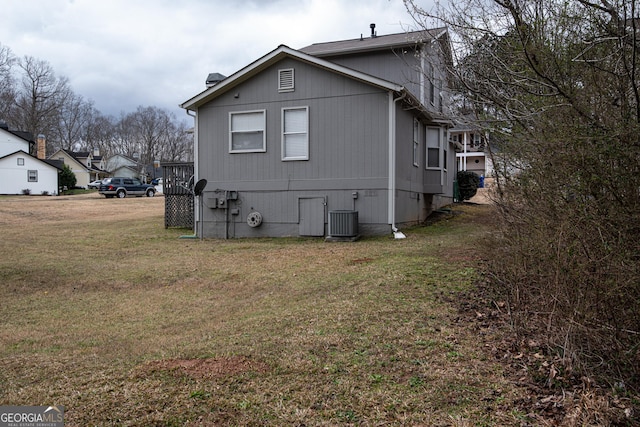 view of property exterior featuring central AC unit and a yard