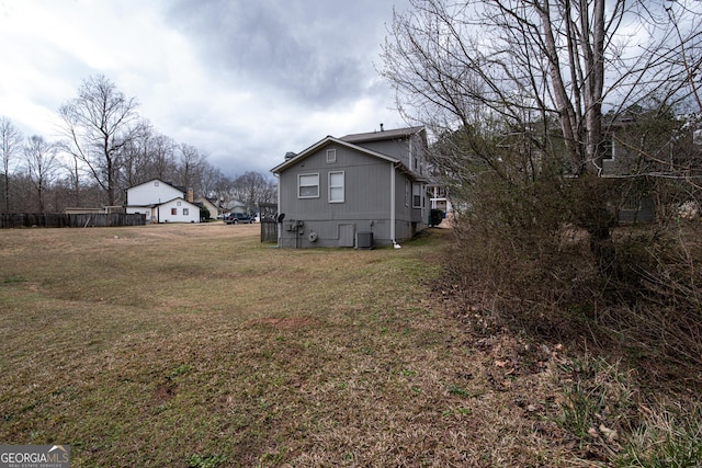 exterior space with central AC and a yard