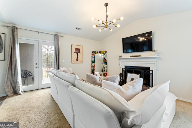 carpeted living area featuring visible vents, vaulted ceiling, french doors, a fireplace, and a chandelier