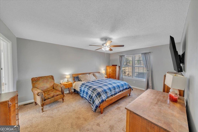 bedroom featuring light colored carpet, ceiling fan, visible vents, and baseboards