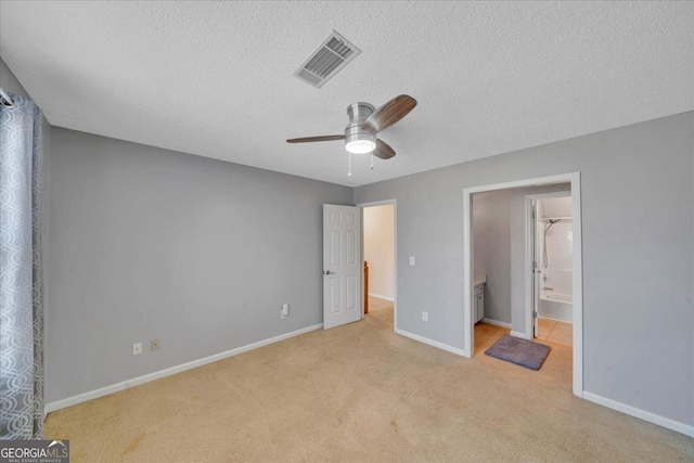 unfurnished bedroom with a textured ceiling, carpet floors, visible vents, and baseboards