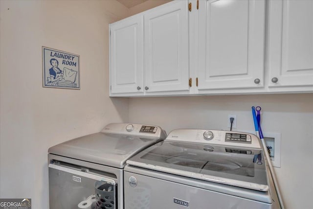 clothes washing area with washer and clothes dryer and cabinet space