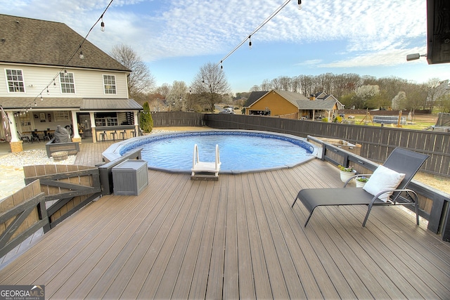 view of pool featuring a deck, outdoor dining space, fence, and a fenced in pool