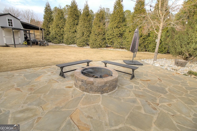 view of patio with an outdoor fire pit and an outdoor structure