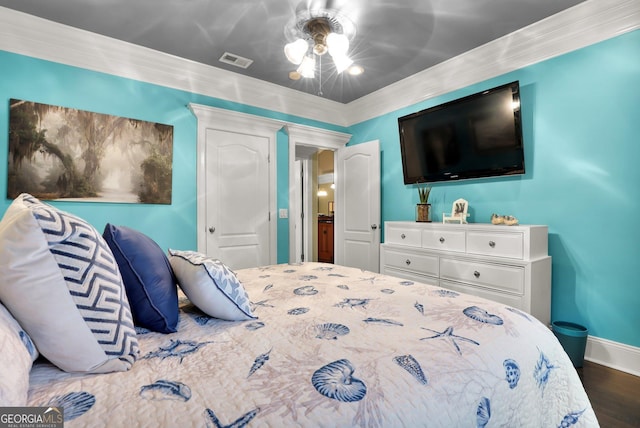 bedroom featuring ornamental molding, wood finished floors, visible vents, and baseboards