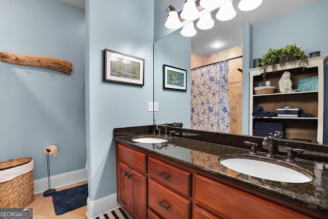 full bath with double vanity, a sink, baseboards, and tile patterned floors