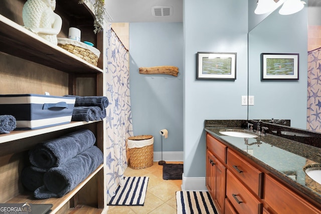 full bath with double vanity, baseboards, visible vents, tile patterned flooring, and a sink