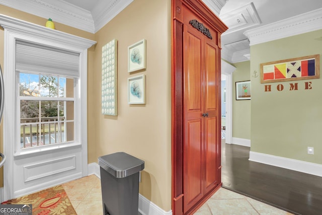 corridor with light tile patterned floors, baseboards, and ornamental molding