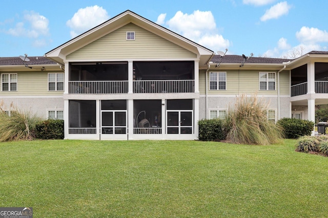 rear view of property with a sunroom and a lawn