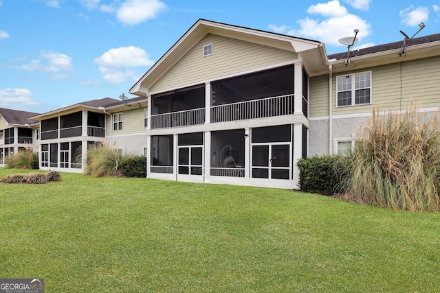 back of property featuring a sunroom and a yard