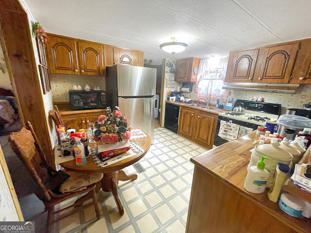 kitchen with brown cabinets, light floors, extractor fan, black appliances, and a sink