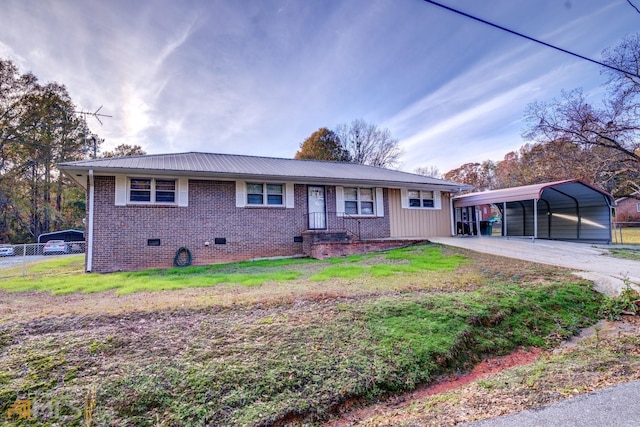 ranch-style house featuring brick siding, a detached carport, crawl space, fence, and a front lawn