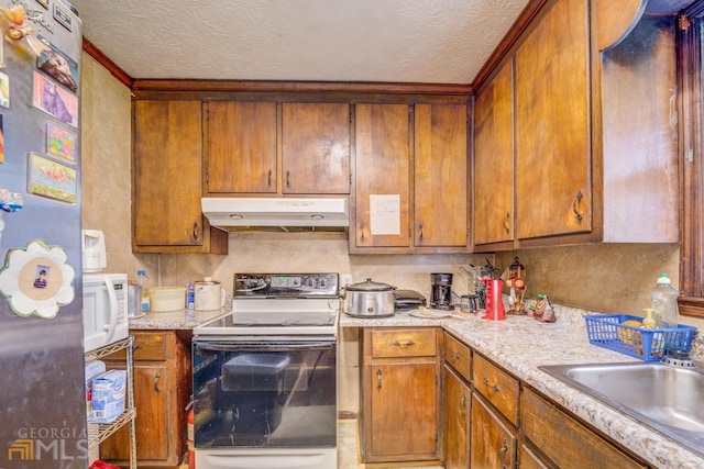 kitchen featuring white microwave, under cabinet range hood, range with electric stovetop, light countertops, and freestanding refrigerator