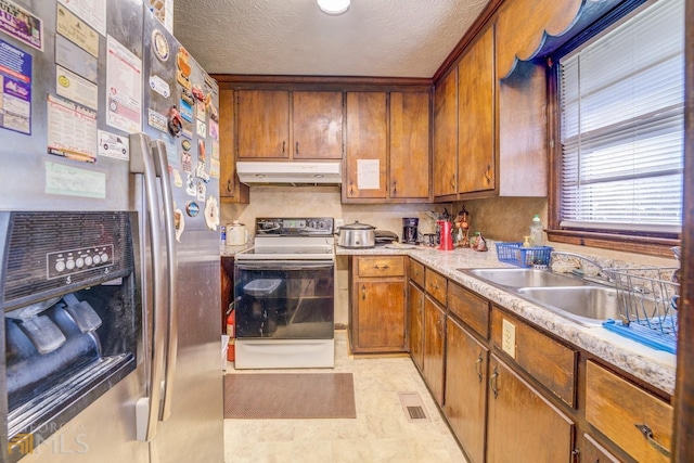 kitchen with white electric range oven, visible vents, freestanding refrigerator, under cabinet range hood, and a sink