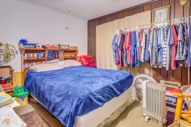 bedroom with crown molding, carpet floors, and radiator