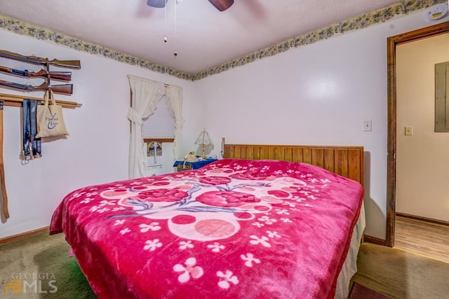 carpeted bedroom with a ceiling fan, electric panel, and baseboards