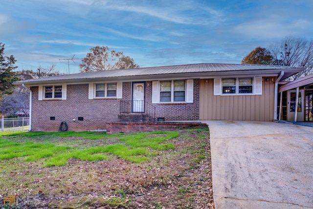 ranch-style home with metal roof, crawl space, a front lawn, board and batten siding, and brick siding