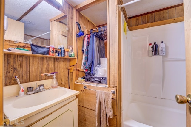 bathroom with wood walls, shower / bathtub combination with curtain, and vanity