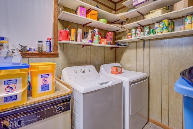 laundry area featuring laundry area, wood walls, and separate washer and dryer