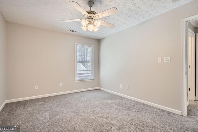 spare room featuring carpet floors, baseboards, and a textured ceiling