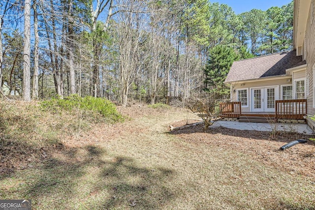 view of yard with a deck and french doors