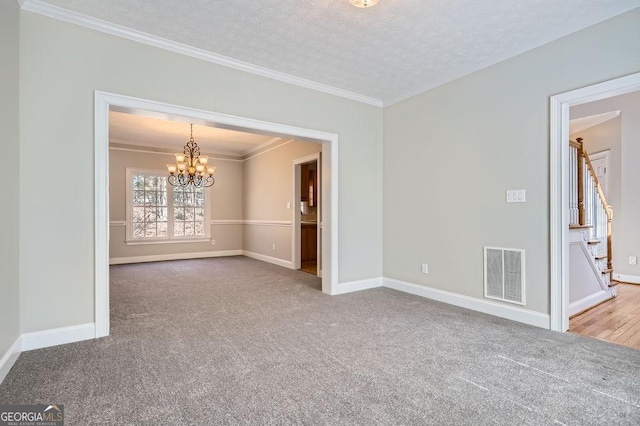 carpeted empty room with baseboards, visible vents, ornamental molding, stairs, and a chandelier