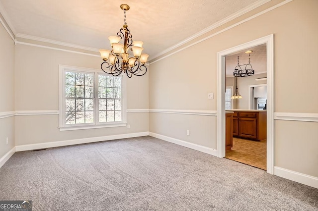 carpeted spare room featuring ornamental molding and baseboards