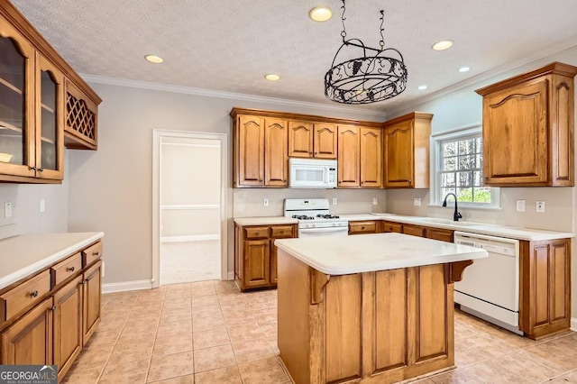 kitchen featuring brown cabinetry, white appliances, light countertops, and a sink