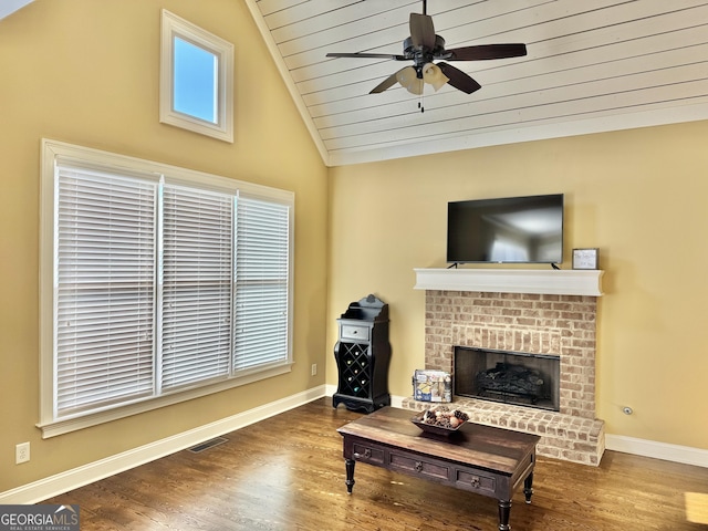 living room with lofted ceiling, a fireplace, visible vents, and wood finished floors