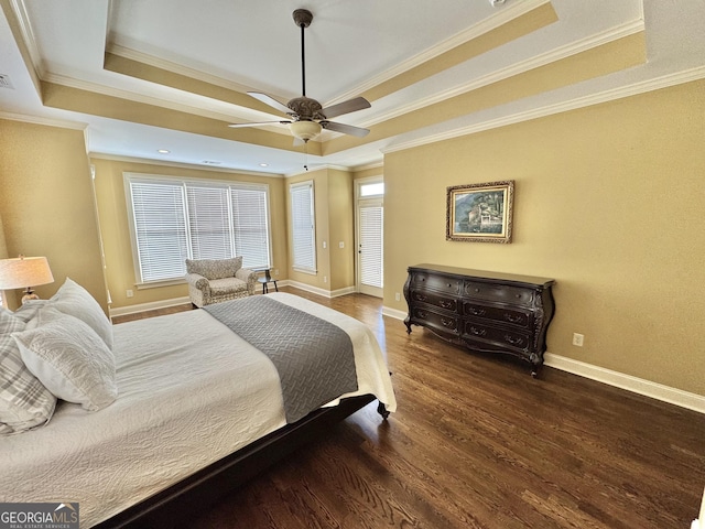 bedroom with crown molding, baseboards, a raised ceiling, and wood finished floors