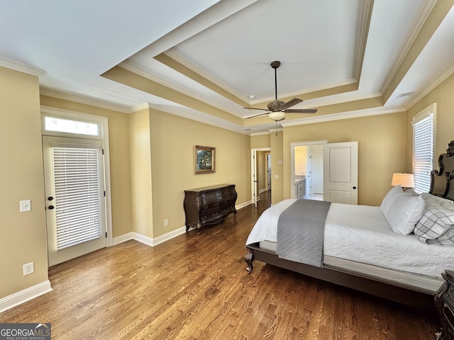 bedroom with baseboards, a raised ceiling, and wood finished floors