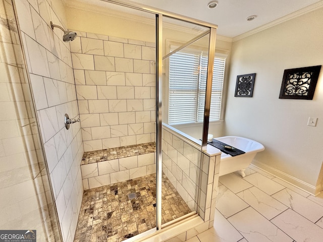 bathroom featuring marble finish floor, a stall shower, a freestanding tub, and crown molding