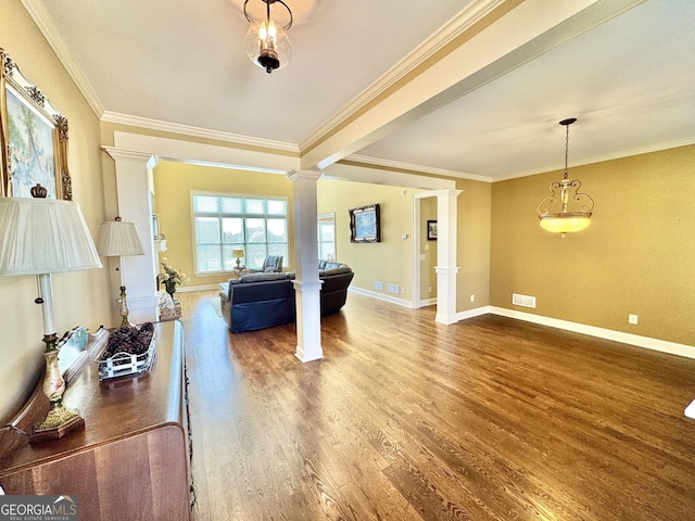 interior space with wood finished floors, visible vents, baseboards, ornamental molding, and decorative columns