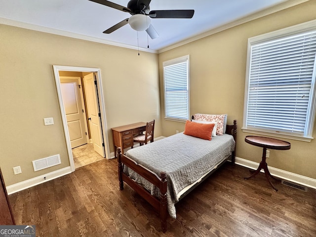 bedroom featuring baseboards, crown molding, visible vents, and wood finished floors