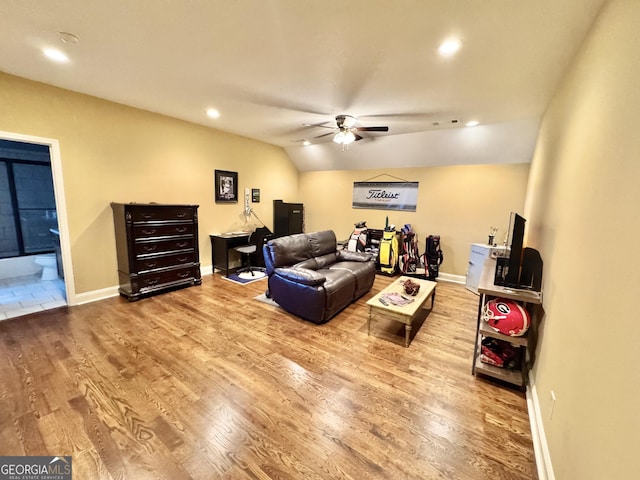 living room with a ceiling fan, baseboards, vaulted ceiling, and wood finished floors