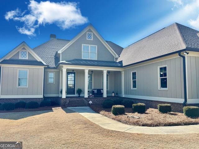 view of front of property with covered porch, a shingled roof, metal roof, and a standing seam roof